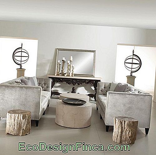 Bilde av et miljø bestående av en benk med speil, to sofaer og to runde kaffebord, i tillegg til gjenstander av kunstdekorasjon. Bordene er plassert mellom de to sofaene og har høyde på samme nivå som sofaen.