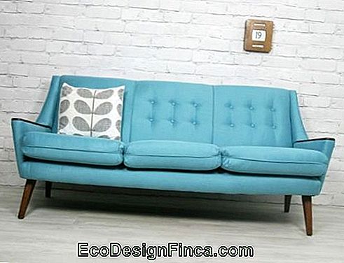 Three-light light blue sofa with light brick wall.