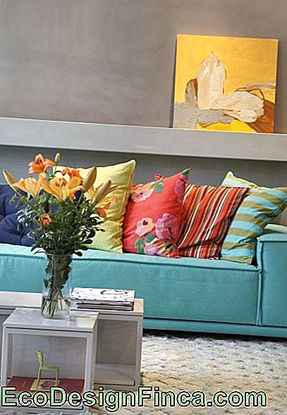 Room with neutral walls and colorful cushions.