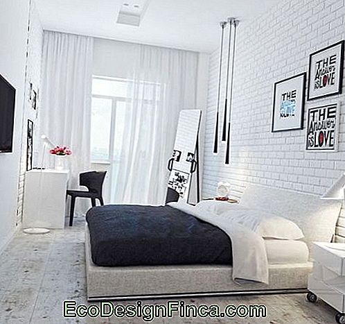 White room with pictures, lamp and floor mirror.