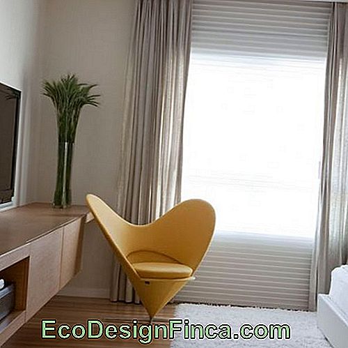 Room with light tones and modern yellow armchair.
