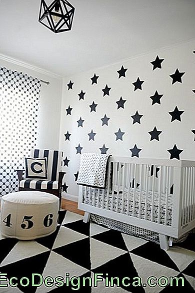 Geometrisk svart og hvitt teppe i babyens rom