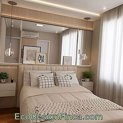 Double bedroom with mirror on the bedside wall.