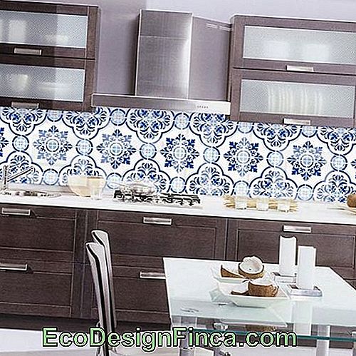 Virtuvės skaitiklis su keliais stalčiais priešais sieną, visiškai padengtas portugalinėmis plytelėmis pagal geometrines figūras.