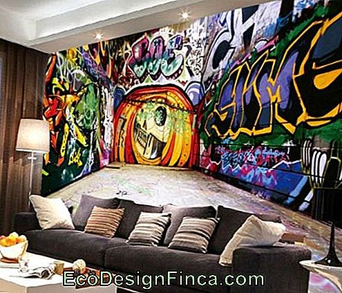 Image d'une pièce où, sur le mur derrière le canapé, se trouve un graphite en trois dimensions avec beaucoup de couleurs et de lettres.