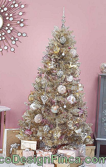 Nåden til denne juledekorasjonen med gyldent juletre er den rosa veggen til ryggen som er kontrasterende med ornamentens farge
