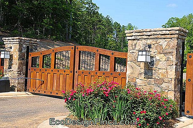 Aiuola aiuta a comporre l'ingresso di questa fattoria, accanto al cancello di legno e colonne di ferro e pietra