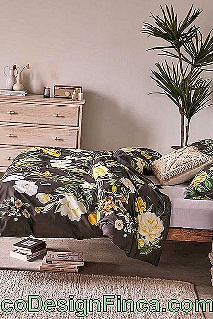 La chambre double parie sur l'imprimé floral pour le linge de lit; le fond noir et les grandes fleurs jaunes décorent l'environnement sans clichés