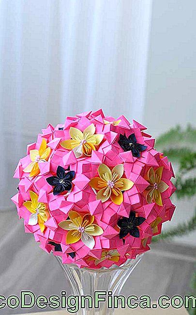 Vazonun ucuna origami çiçek yerleştirildi, farklı renklerde küçük çiçekler ve her birinin çekirdeğine küçük boncuklar yerleştirildi.
